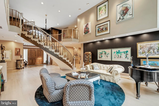 living room with light hardwood / wood-style floors and a high ceiling