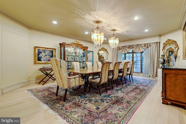 dining room featuring an inviting chandelier, ornamental molding, and light wood-type flooring