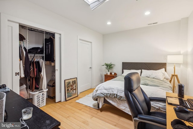 bedroom featuring wood finished floors, a closet, a walk in closet, visible vents, and recessed lighting