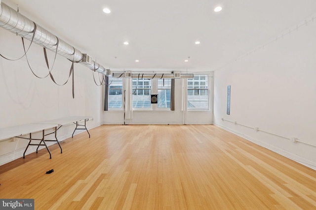 interior space with baseboards, recessed lighting, and wood finished floors