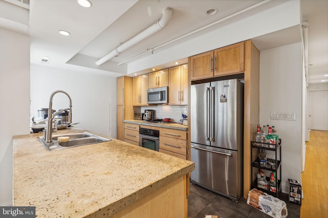 kitchen featuring backsplash, light brown cabinetry, dark wood-type flooring, sink, and stainless steel appliances