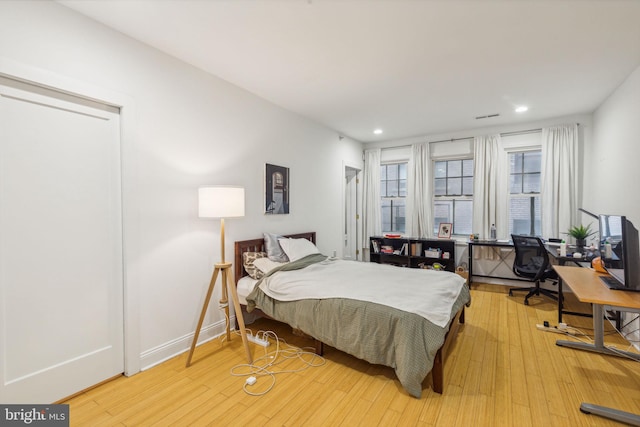 bedroom with recessed lighting and wood finished floors