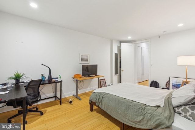 bedroom with baseboards, recessed lighting, and light wood-type flooring