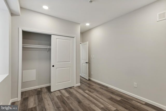 unfurnished bedroom with a closet and dark wood-type flooring