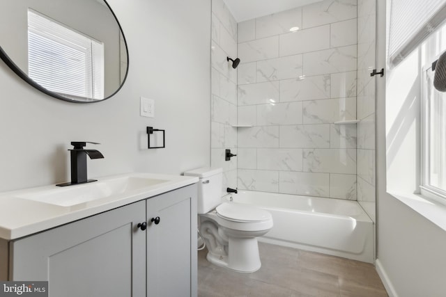 full bathroom featuring tiled shower / bath combo, vanity, and toilet