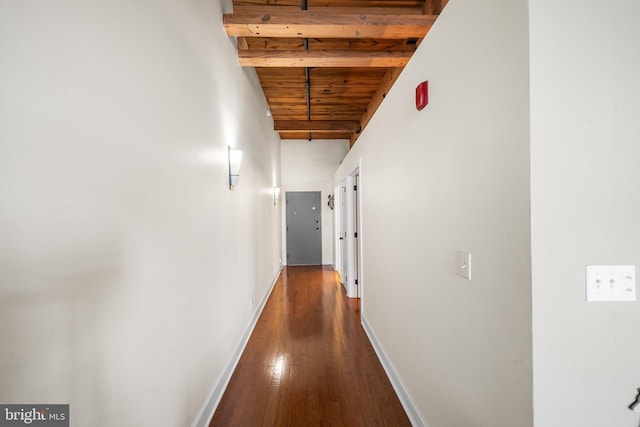 corridor featuring wooden ceiling, dark hardwood / wood-style floors, and beam ceiling