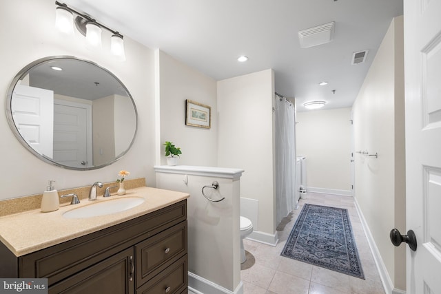 bathroom with toilet, tile patterned floors, and vanity