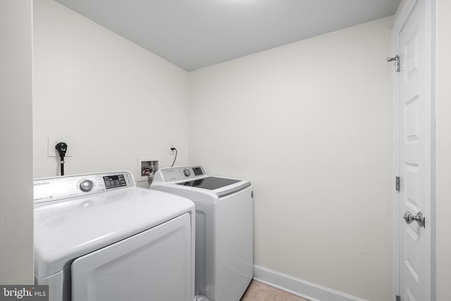 clothes washing area featuring washer and dryer and light tile patterned floors