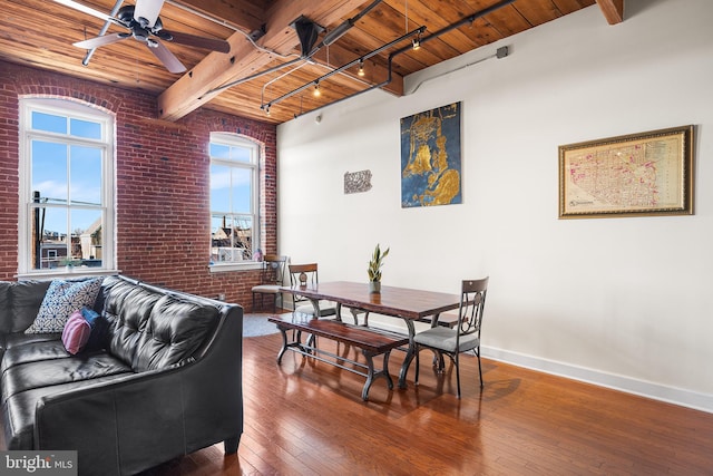 dining area with brick wall, wood ceiling, hardwood / wood-style floors, ceiling fan, and beamed ceiling