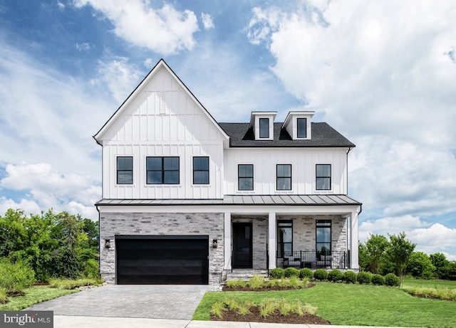 modern farmhouse style home with a garage, covered porch, and a front lawn