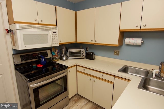 kitchen with light hardwood / wood-style flooring and electric range