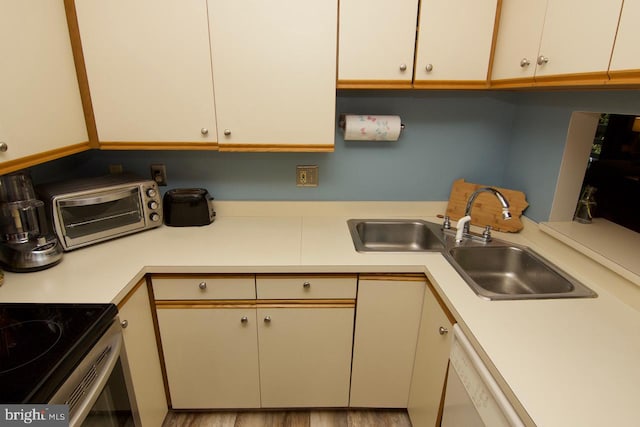 kitchen featuring light wood-type flooring, sink, and white dishwasher