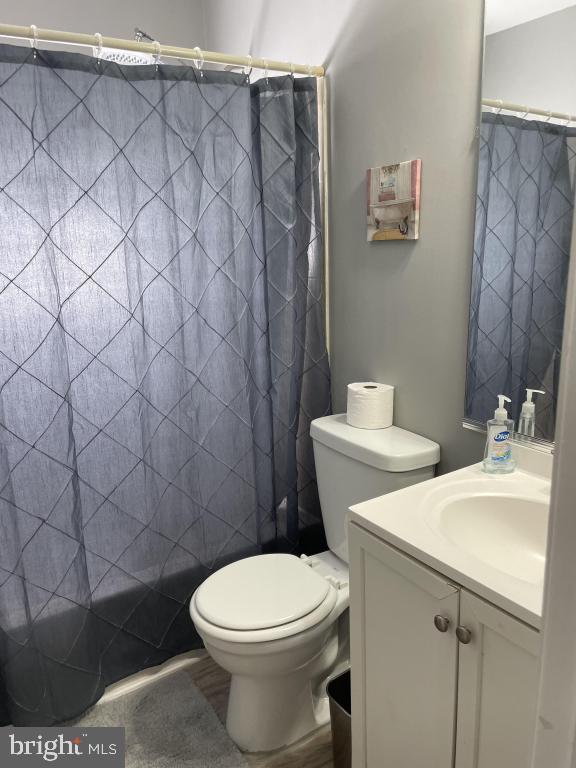 bathroom with a shower with curtain, vanity, and toilet