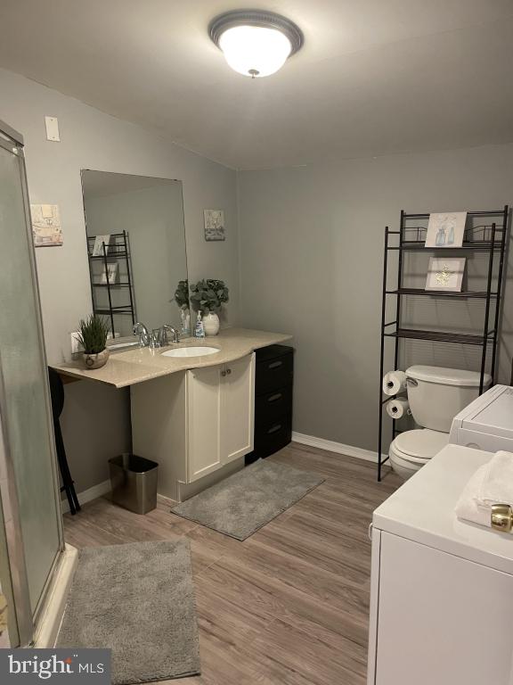 laundry room featuring washer and clothes dryer, light hardwood / wood-style floors, and sink