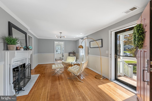 1307 Cleveland St, Alexandria, VA 22302 - dining space with light wood-type flooring, ornamental molding, a tiled fireplace, recessed lighting, and a chandelier