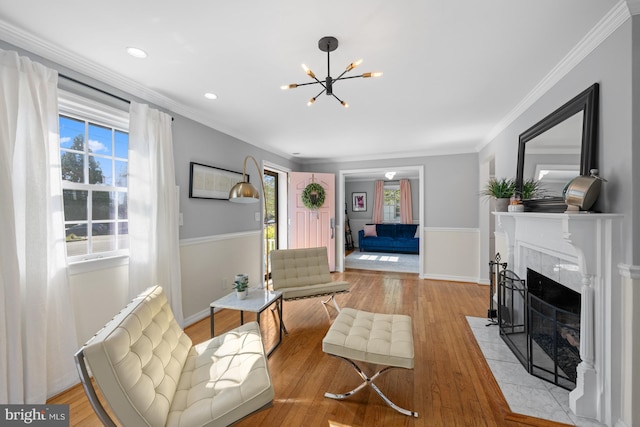 1307 Cleveland St, Alexandria, VA 22302 - living area featuring healthy amount of natural light, a chandelier, a tile fireplace, light wood-type flooring, and crown molding