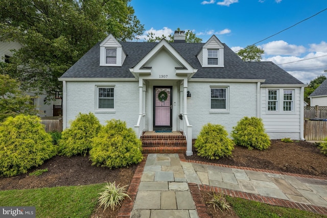1307 Cleveland St, Alexandria, VA 22302 - cape cod house with roof with shingles, a chimney, and brick siding