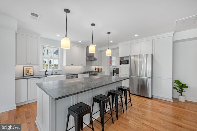 1307 Cleveland St, Alexandria, VA 22302 - kitchen with appliances with stainless steel finishes, a kitchen island, a kitchen bar, decorative backsplash, and recessed lighting
