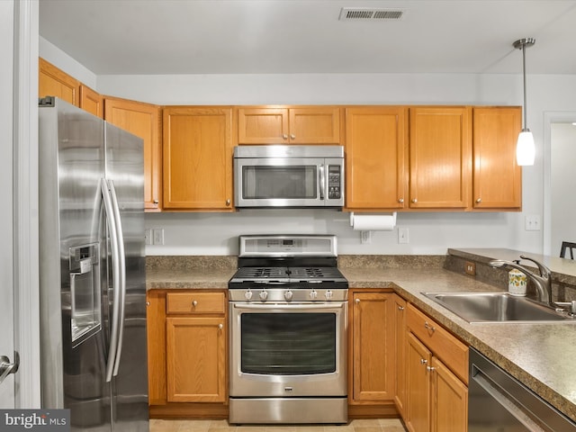 kitchen featuring pendant lighting, stainless steel appliances, and sink