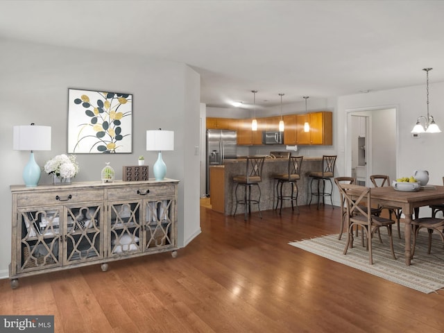 dining room with an inviting chandelier and dark hardwood / wood-style floors