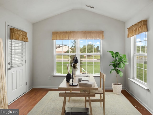 dining room featuring vaulted ceiling, dark hardwood / wood-style floors, and a wealth of natural light