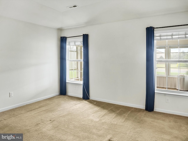 carpeted spare room featuring a healthy amount of sunlight