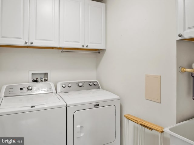 laundry area featuring washing machine and clothes dryer, cabinets, and sink