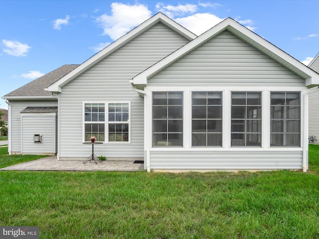 back of property with a sunroom and a yard