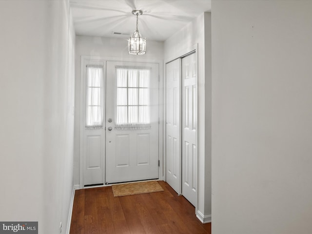 doorway to outside featuring wood-type flooring and a chandelier