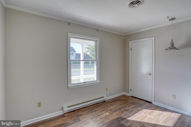 spare room with dark hardwood / wood-style floors, a baseboard heating unit, and ornamental molding