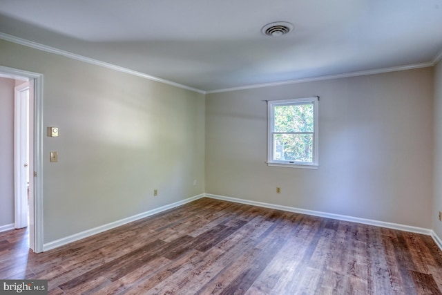 empty room featuring ornamental molding and dark hardwood / wood-style floors