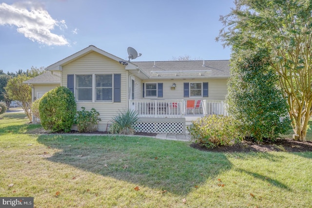 back of property featuring a wooden deck and a lawn