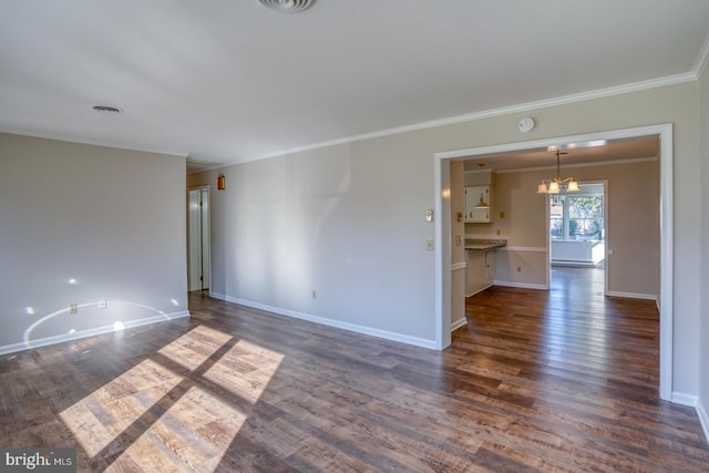 spare room with ornamental molding, a chandelier, and dark hardwood / wood-style flooring