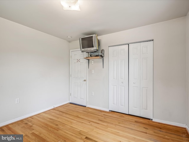 unfurnished bedroom featuring light hardwood / wood-style floors and a closet