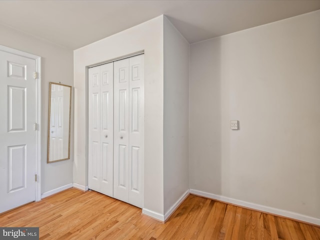 unfurnished bedroom featuring light hardwood / wood-style floors and a closet