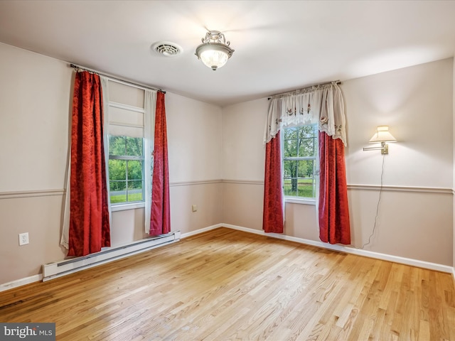 unfurnished room with wood-type flooring and a baseboard radiator