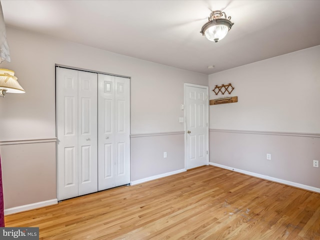 unfurnished bedroom with a closet and light wood-type flooring