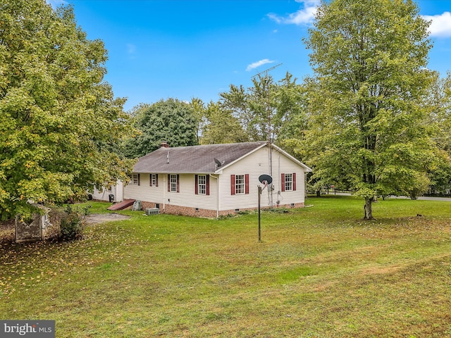 view of front of property with a front lawn and central AC