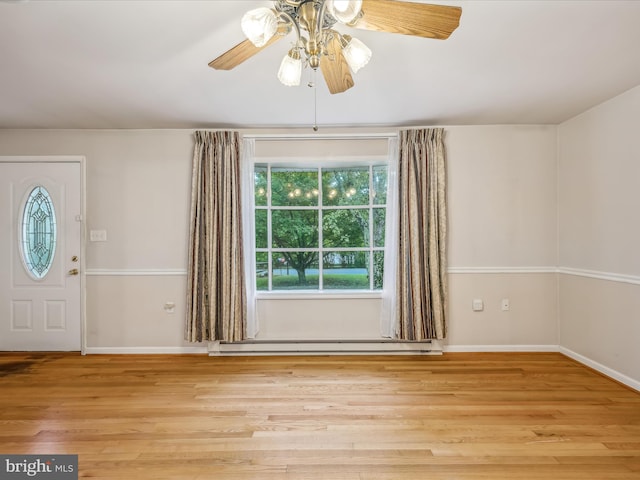 entryway with light hardwood / wood-style flooring, ceiling fan, and baseboard heating