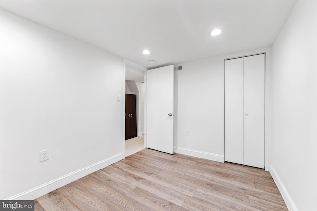 unfurnished bedroom featuring light hardwood / wood-style flooring and a closet