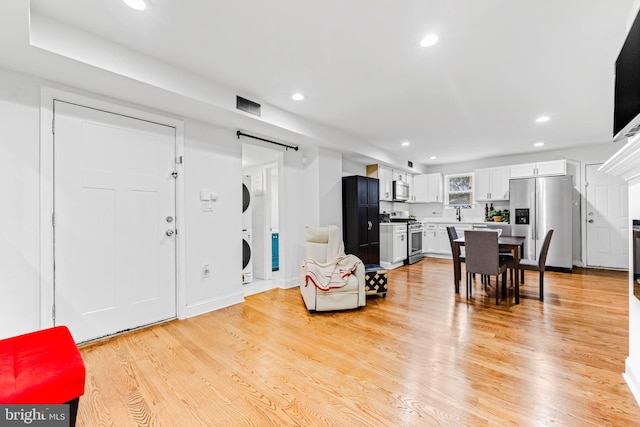 interior space featuring light hardwood / wood-style flooring and stacked washer / dryer