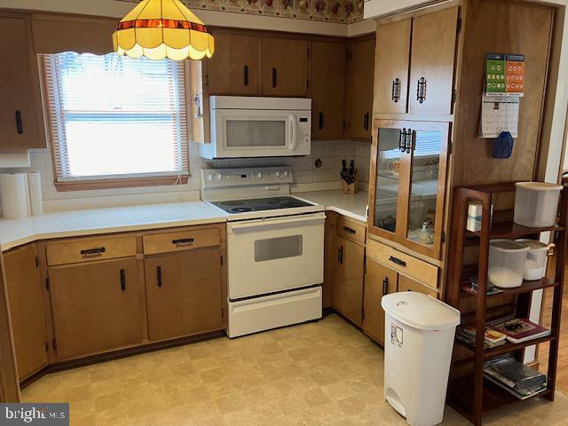 kitchen featuring tasteful backsplash and white appliances