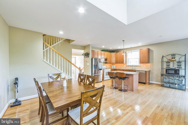 dining space with light hardwood / wood-style flooring and sink