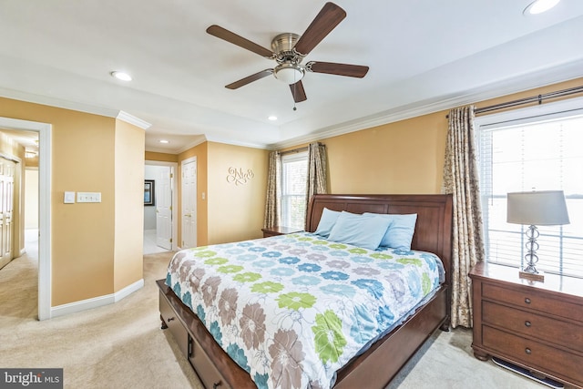 bedroom with multiple windows, light colored carpet, ceiling fan, and ensuite bathroom