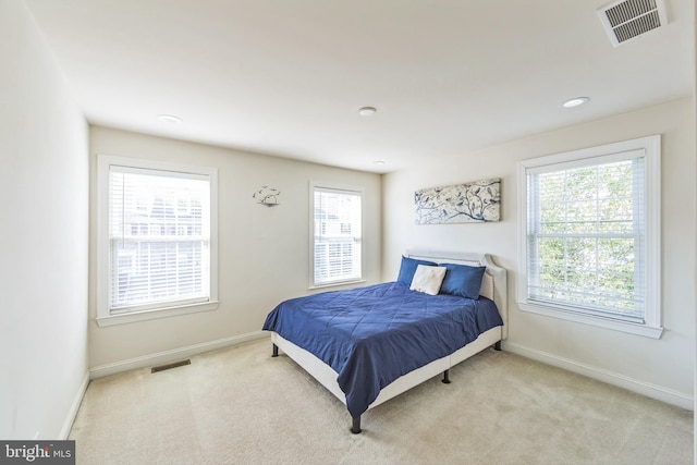 carpeted bedroom with multiple windows