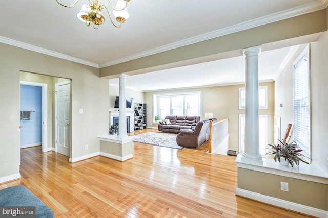 living room with crown molding, hardwood / wood-style floors, and ornate columns