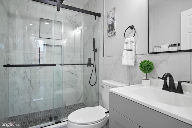 bathroom with tile walls, walk in shower, vanity, and toilet