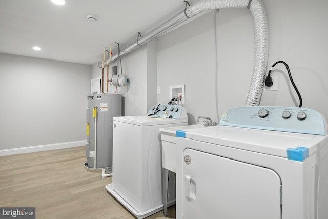 washroom featuring separate washer and dryer, water heater, and light wood-type flooring