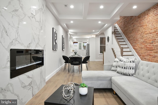 living room with brick wall and light wood-type flooring