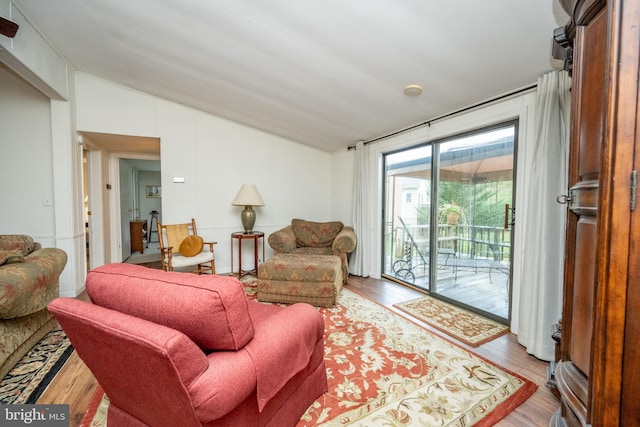 living room with light hardwood / wood-style flooring and vaulted ceiling